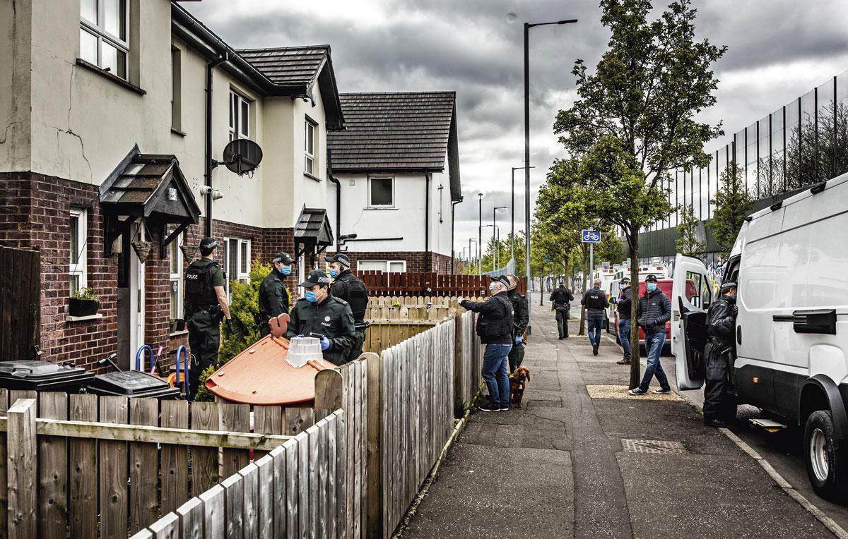 Een huiszoeking van de politie in de pro-Britse wijk, recht tegenover de vredesmuur.