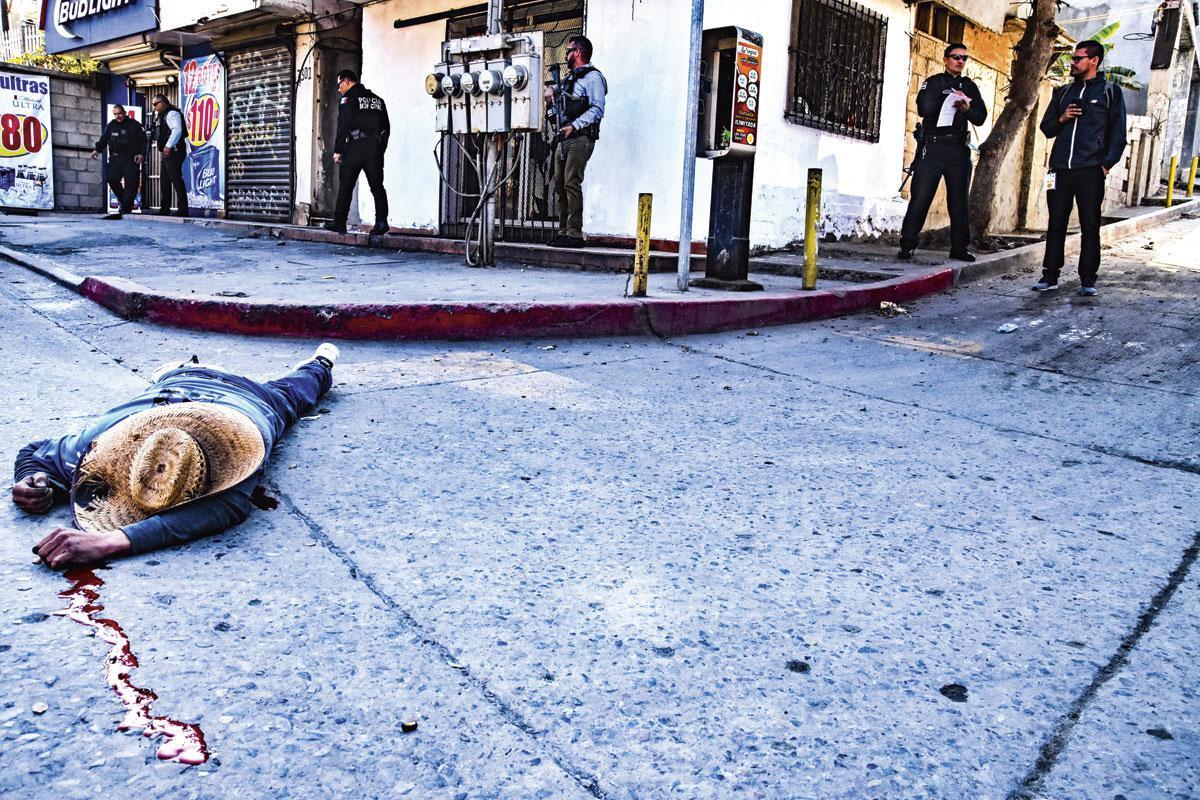 Het slachtoffer van een afrekening tussen methdealers op klaarlichte dag in Tijuana. Elke maand vallen er 100 à 200 doden in de gevaarlijkste stad van Mexico.