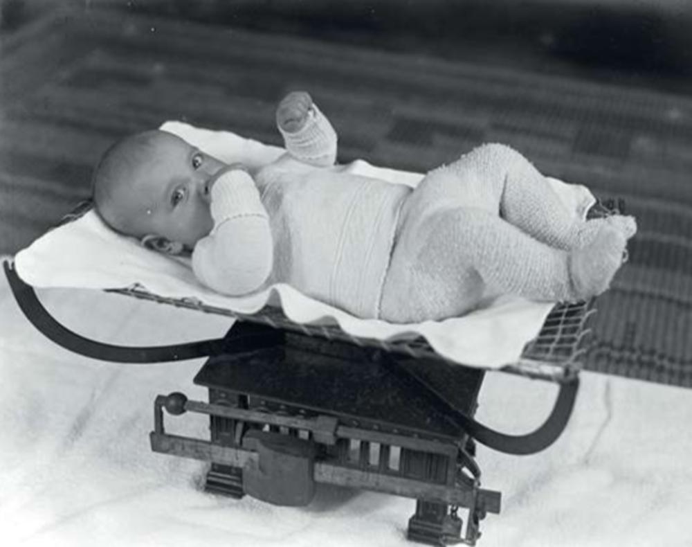 Het regelmatig wegen van baby's is een vast ritueel om hun ontwikkeling te volgen. Foto uit 1936. (Fotocoll. Van de Poll)