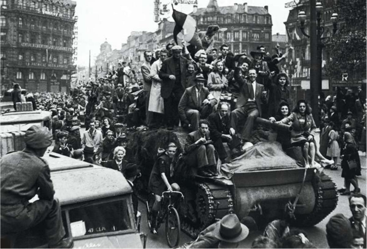 Brussel, 3 september 1944: Belgische burgers verwelkomen de Britse bevrijders en springen op hun tanks die door de stad rijden.