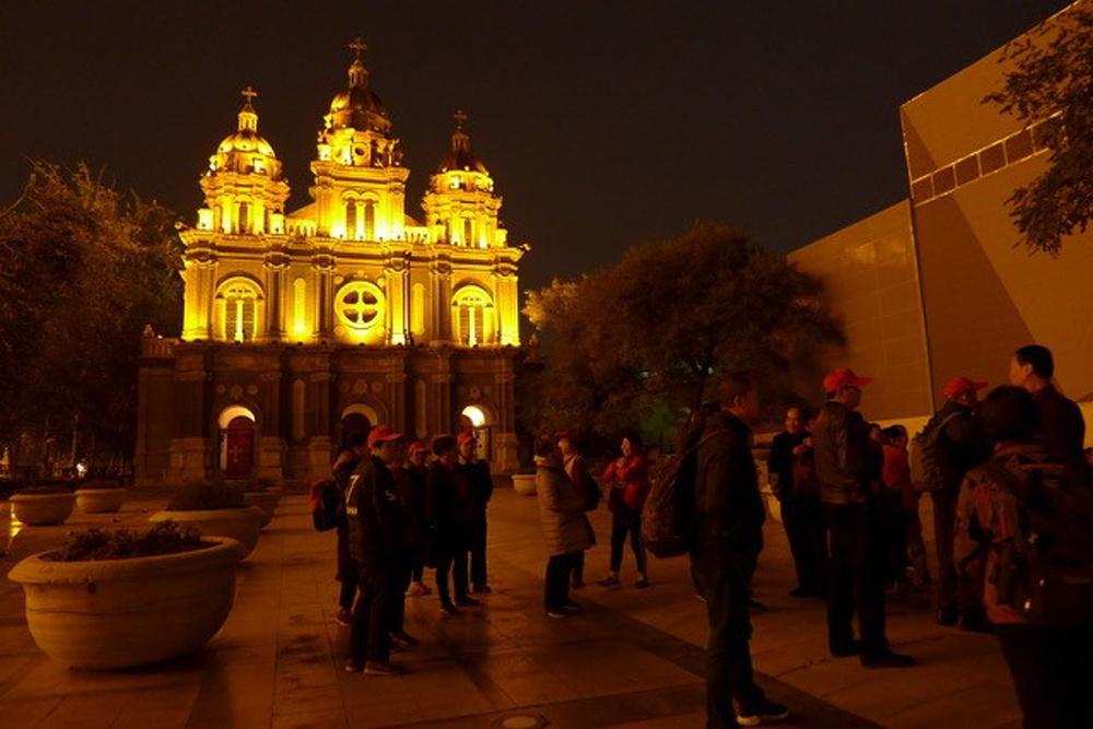 Peking: het plein voor de kathedraal, met groepen pelgrims.