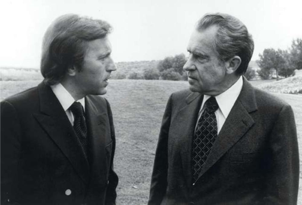 Sterreporter David Frost interviewt president Richard Nixon op 19 mei 1977. Henry Kissinger is zijn toe-holder.