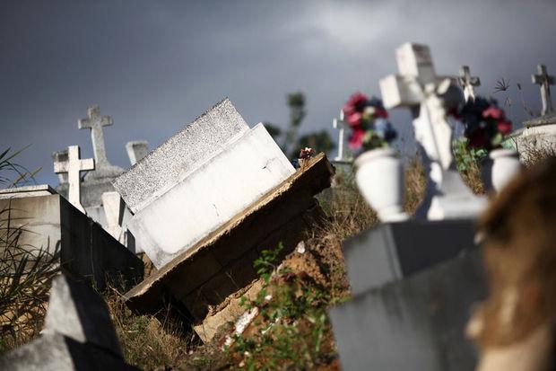 Grafzerken liggen er beschadigd bij na de doortocht van orkaan Maria op de begraafplaats van Lares, Puerto Rico, 8 februari 2018.
