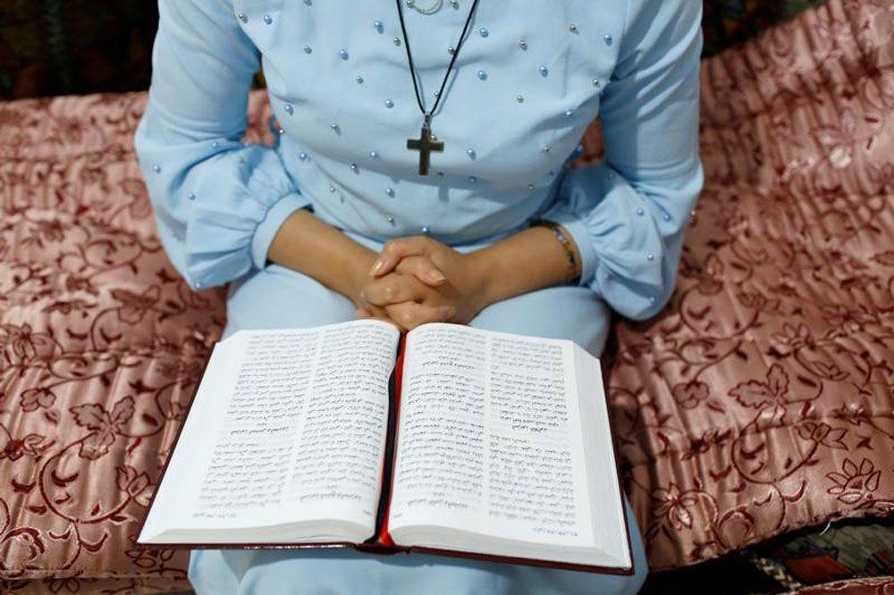 Een Marokkaanse vrouw die zich bekeerd heeft tot het christendom houdt een gebedsboek op schoot in een huis dat als kerk gebruikt wordt in Rabat.
