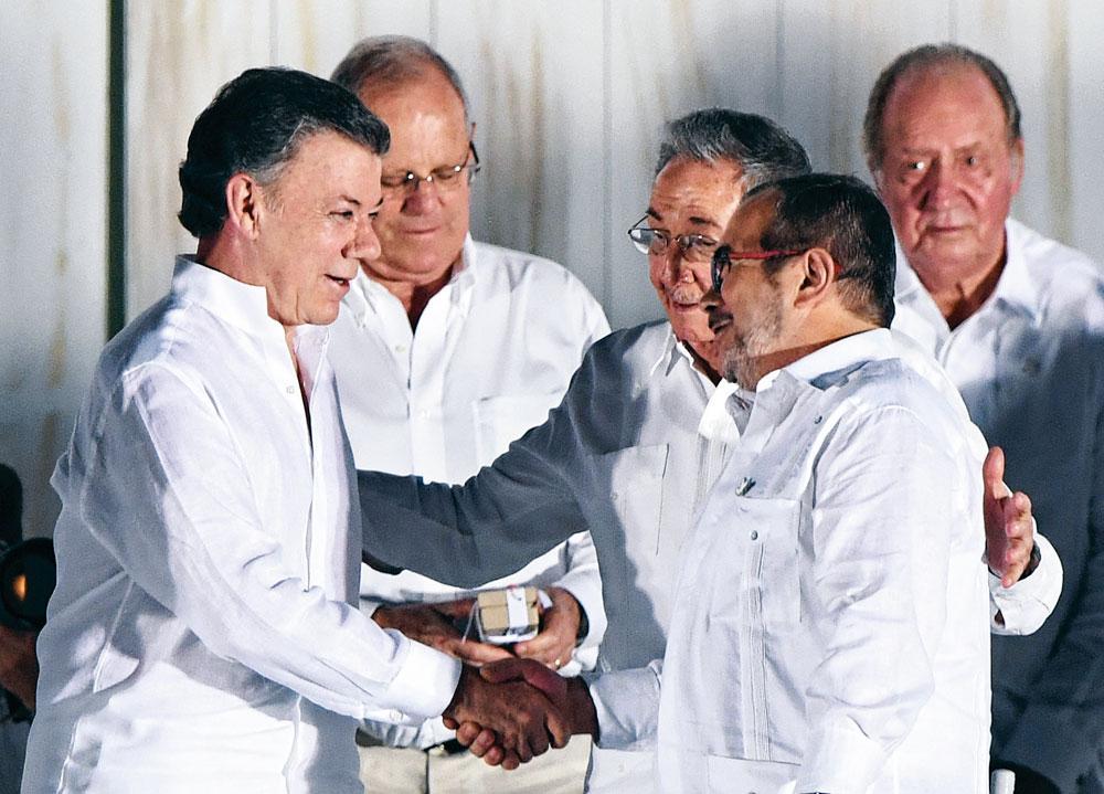 President Santos (links) en FARC-leider Rodrigo Londono (tweede van rechts) bij de ondertekening van het historische akkoord in Cartagena, op 26 september 2016.