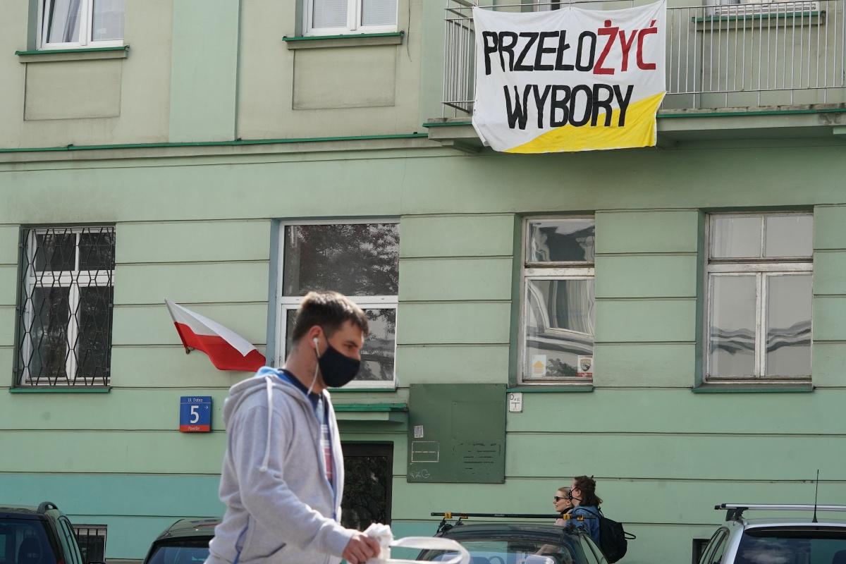 Een affiche in het Poolse Warschau roept op de verkiezingen uit te stellen, 30 april 2020