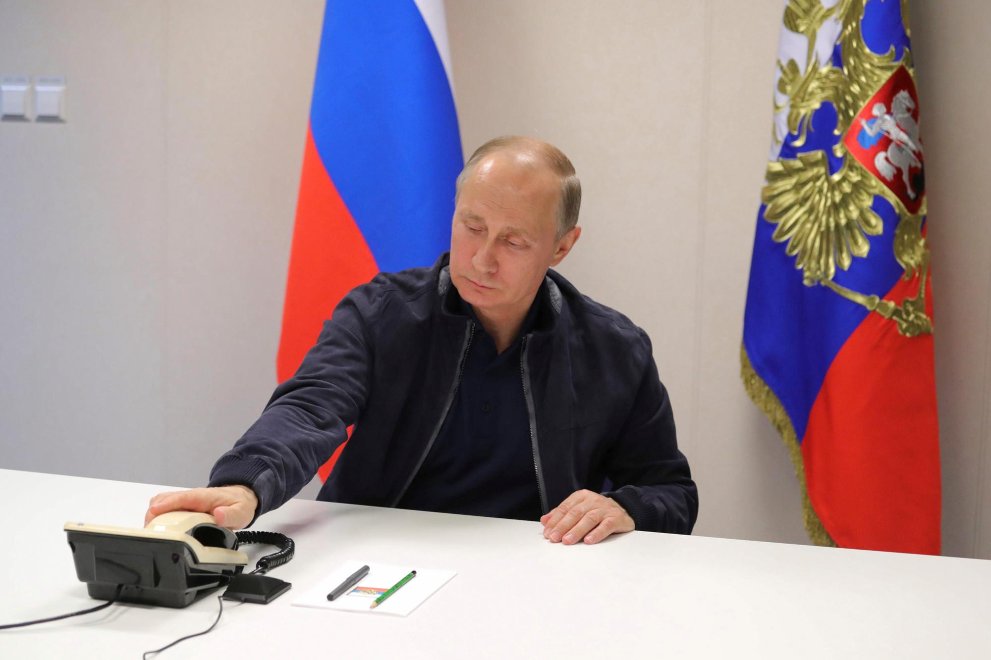 Archiefbeeld van de Russische president Vladimir Poetin die de telefoon opneemt.