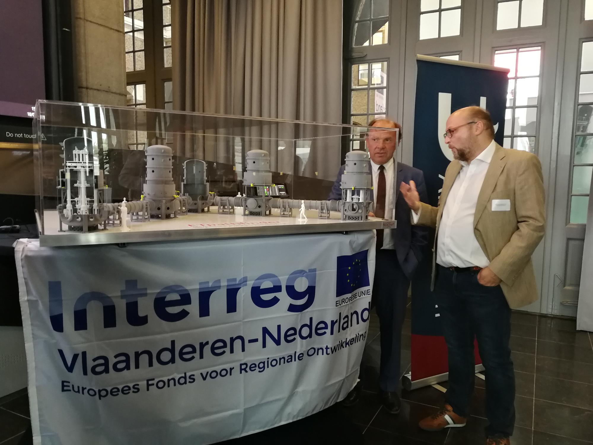 Minister van wetenschapsbeleid Philippe Muyters en fysicus Nick van Remortel onthullen een maquette van 'ET Pathfinder', een hypermoderne faciliteit voor het onderzoek naar gravitatiegolven.