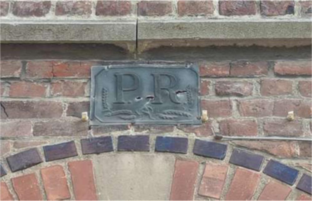 Verzekeringsplaatje op de gevel van het parochiecentrum van Hoegaarden. (Foto Joris Verbaeten)
