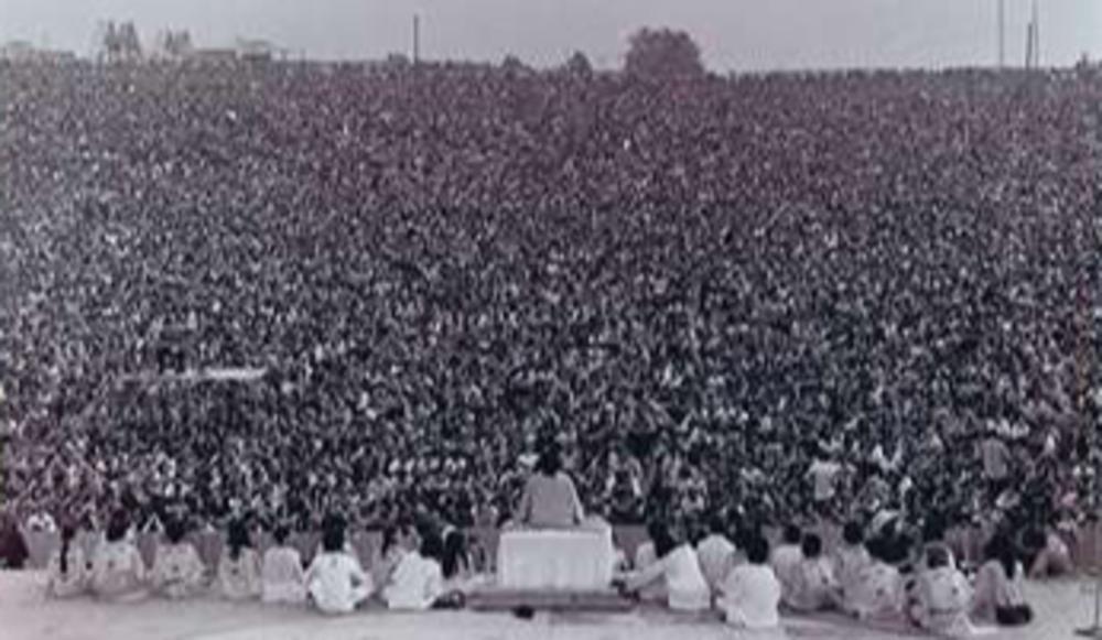 Swami Satchidananda opent 'three days of peace and music'. Woodstock Ventures moest het festival hals over kop in drie weken organiseren nadat bewoners van Wallkill, waar het aanvankelijk zou plaatsvinden, het hadden tegengehouden.