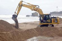 Archiefbeeld van een bulldozer op het strand van Biarritz in Frankrijk. In 2015 werd op het strand een duin aangelegd om de kustlijn te beschermen tegen erosie tijdens een hevige winterstorm.