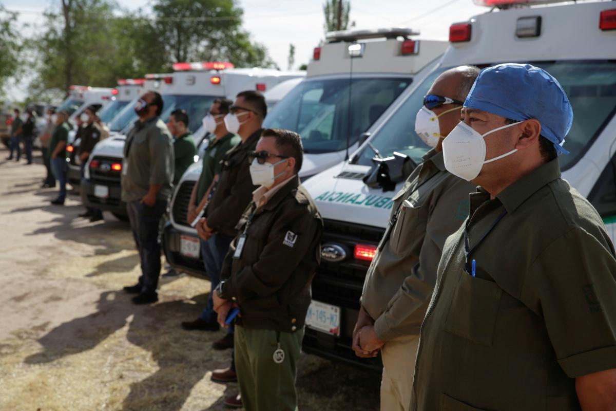 Ambulanciers wonen de begrafenis bij van een collega die overleed aan covid-19, Ciudad Juarez, 14 mei 2020