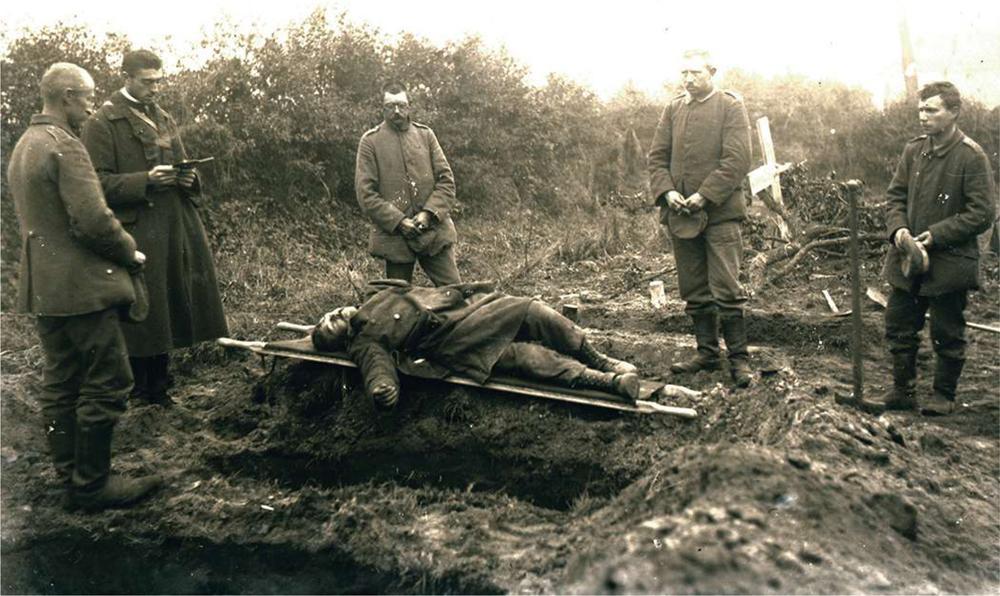 Begrafenis van een gesneuvelde Belgische militair, 15-10-1918. Krijgsgevangen Duitse soldaten hebben het lichaam tot aan het graf gedragen en brengen de laatste eer. Tijdens de Groote Oorlog stierven ongeveer 40.000 Belgische militairen.