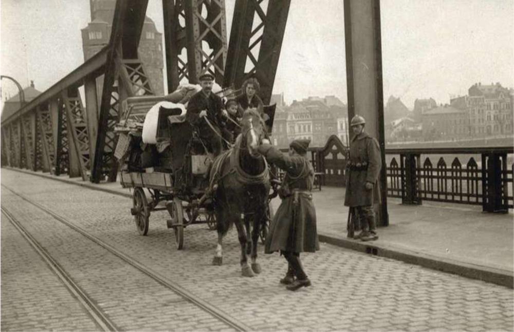 Aan een brug over de Rijn in Homburg controleren Belgisch soldaten een Duitse gezin uit het Ruhrgebied dat op de vlucht is voor de linkse opstanden.