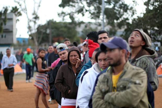 Migranten uit de karavaan staan in de rij voor een opvang in Tijuana, Mexico