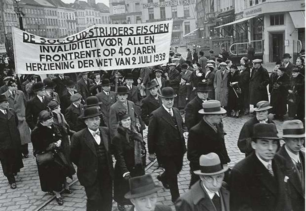 AV: 'De oud-strijders dwongen een sociaal statuut voor zichzelf af, maar het was hen ook om maatschappelijke rechtvaardigheid te doen.' Socialistische oud-strijders maken hun eisen kenbaar tijdens de 1 meistoet op de Korenmarkt in Gent, 1938.