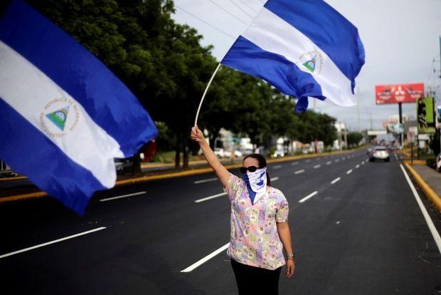 Een betoger zwaait met de vlag van Nicaragua tijdens protesten tegen president Daniel Ortega, Managua, 2 juli 2018 