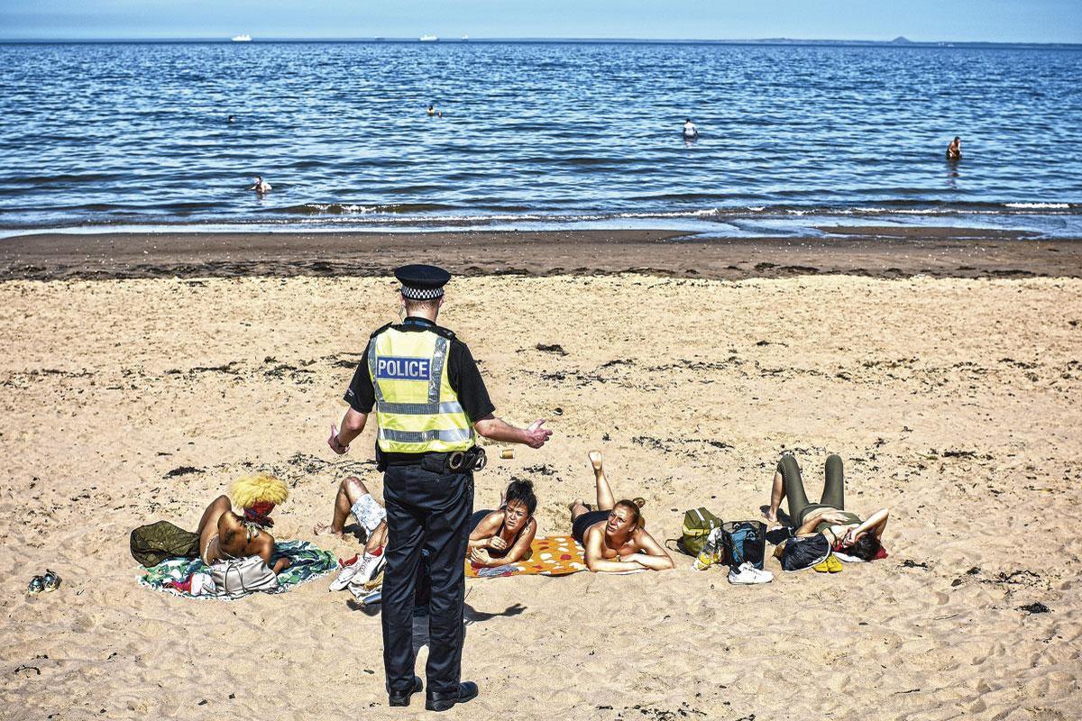 Politiecontrole op het strand in Edinburgh. 'We houden de lockdownmaatregelen aan tot het aantal gevallen gedaald is tot onder de tien.'