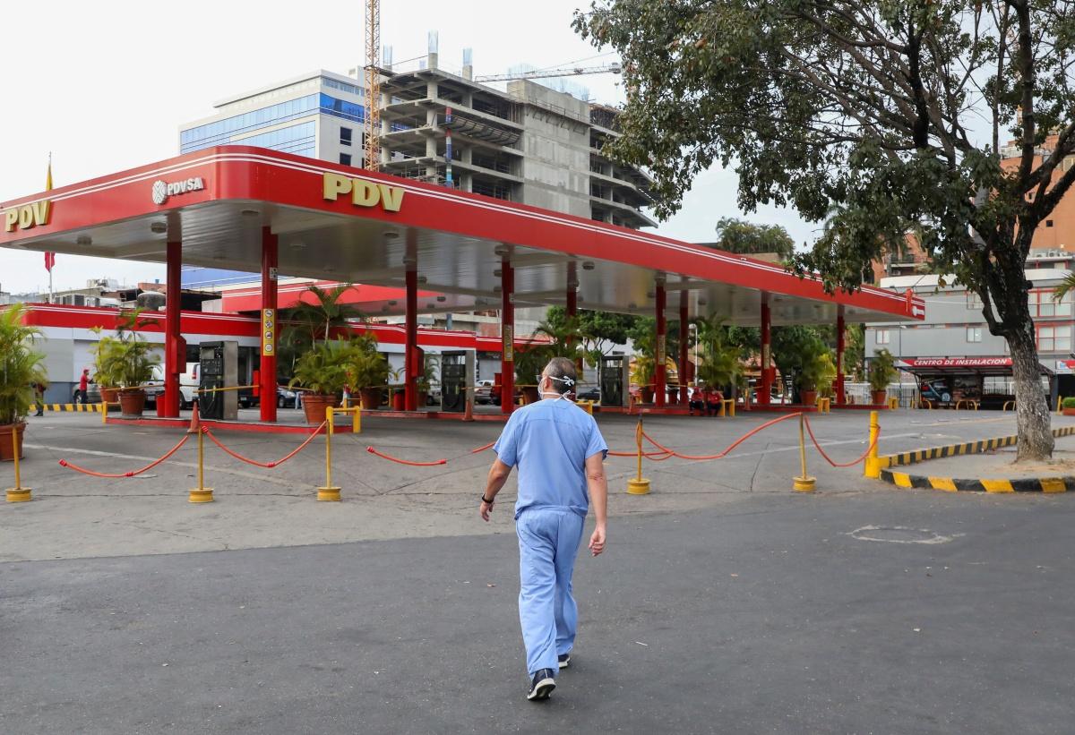 Een dokter bij een gesloten tankstation in Caracas. Naast het coronavirus heeft Venezuela ook te kampen met nijpende brandstoftekorten. 