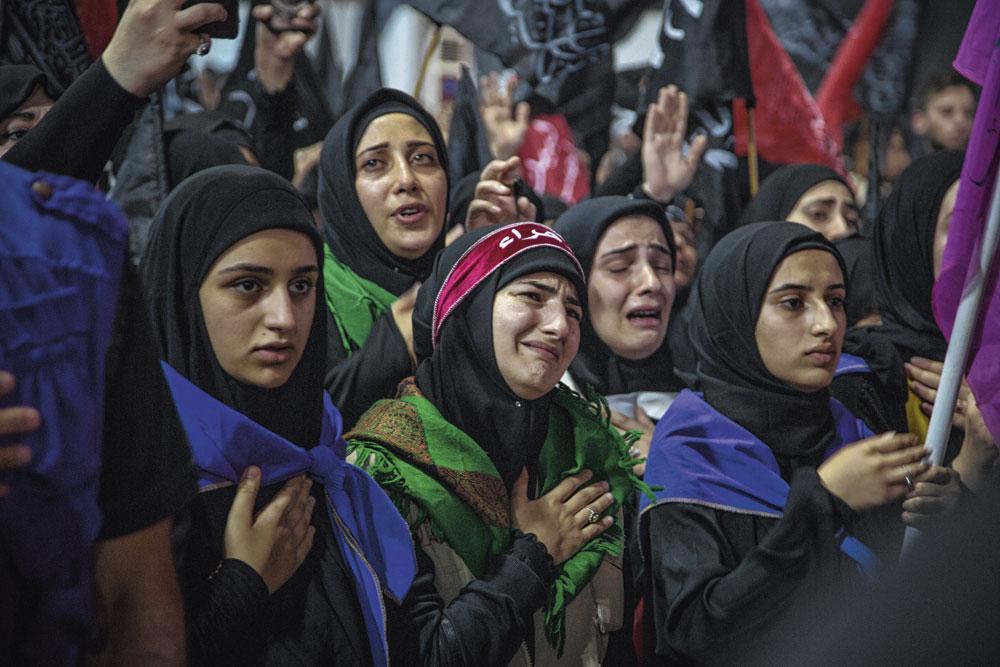 Een groep meisjes uit Bahrein staat in de stoet. De aanblik van Hoesseins begraafplaats wekt felle emoties op.