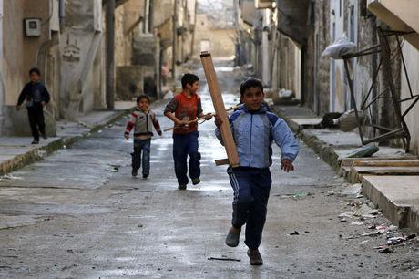 Kinderen lopen met speelgoedwapens door de straten van Aleppo.