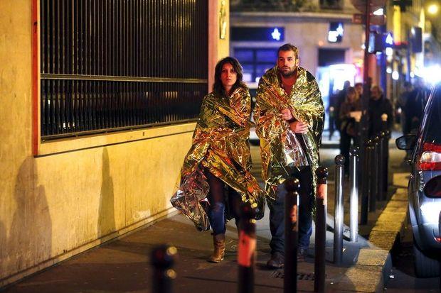 Parijzenaars, die de aanslagen overleefd hebben, wandelen in de buurt van concertzaal Bataclan