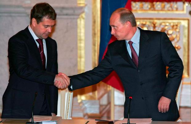 Poetin schudt de hand van zijn trouwe medewerker en toen nog vicepremier Dmitri Medvedev in 2005.