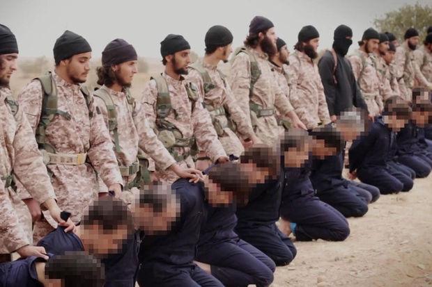 Een still uit de propagandavideo van Islamitische Staat toont jihadi's die zich voorbereiden op de simultane onthoofding van minstens 15 mannen, vermoedelijk uit het Syrische regeringsleger van president Bashar al-Assad. 