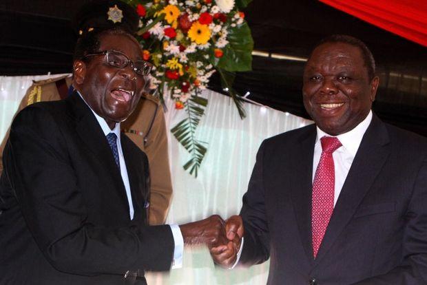 Robert Mugabe grapt met eerste minister Morgan Tsvangirai na het ondertekenen van een nieuwe grondwet, Harare, 22 mei 2013. 