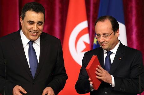 De Tunesische premier Mehdi Jomâa (links) overhandigt de nieuwe grondwet aan Franse president François Hollande.