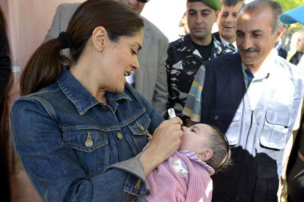 Actrice Salma Hayek dient een poliovaccin toe aan een Syrische vluchtelingenbaby in de Bekavallei.