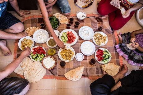 Middagmaal op de grond in Idris' appartement in Gaziantep. Er is geen plaats voor tafels of matrassen. 