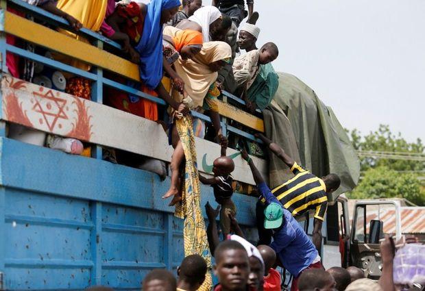 Nigerianen op de vlucht voor terreurorganisatie Boko Haram halen hun kinderen uit een vrachtwagen in Maiduguri, een arme stad van meer dan een miljoen inwoners die kreunt onder de enorme instroom van vluchtelingen 