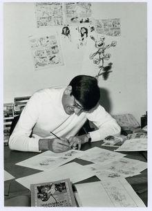 Franquin tekent Guust, met een exemplaar van National Geographic binnen handbereik.