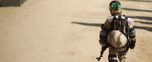 Een Palestijnse jongen in militaire plunje is op weg naar een afstudeerceremonie voor jongeren die een trainingskamp van Hamas vervolledigden.
