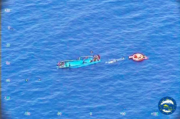 Migranten op een zinkende boot, tijdens een reddingsopertie van de Spaanse kustwacht voor de Libische kust (26 mei 2016).