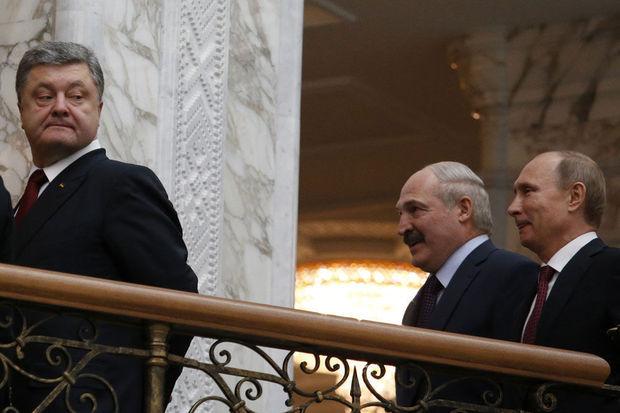 De Oekraïense president Petro Porosjenko kijkt over zijn schouder naar de Russische president Vladimir Poetin (rechts).