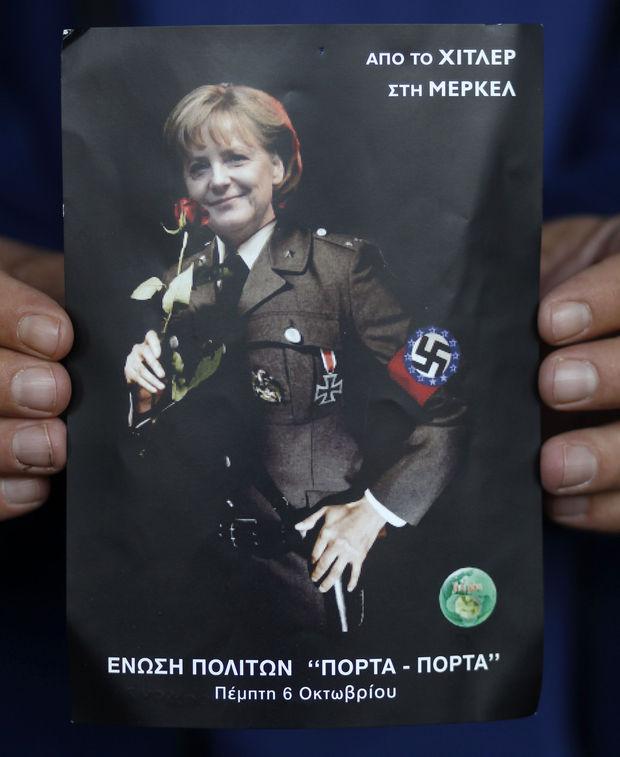 Een poster met het Griekse opschrift: 'Van Hitler, aan Merkel'