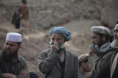 Ontzette Afghanen in het door een modderstroom vernielde dorp.