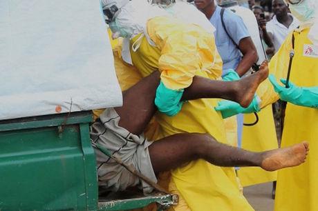 Gezondheidswerkers duwen een gevluchte ebolapatiënt in een ambulance. 