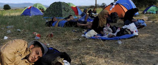 Enkele slapende vluchtelingen op een veldje aan de Grieks-Macedonische grens.