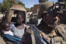 Een moeder met haar kind en een Franse soldaat in Mali. 