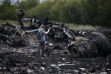Een journalist neemt foto's van de crashsite van vlucht MH17 in Oost-Oekraïne.