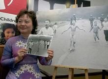 Kim Phuc poseert naast de beroemde foto uit 1972.