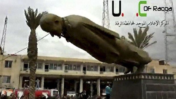 Het standbeeld van Hafez Assad in Raqqa wordt neergehaald