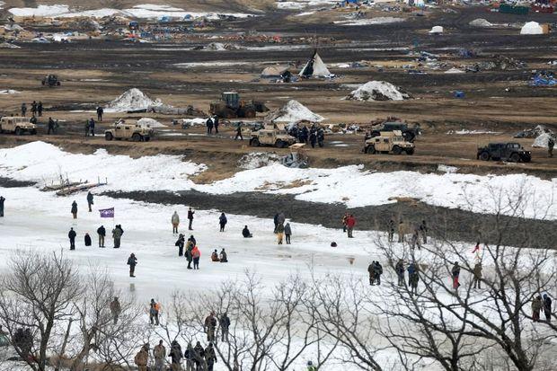 Actievoerders op de bevroren Cannonballrivier op 23 februari jl. Bovenaan de foto zijn auto's en agenten te zien die het Oceti-kamp ontruimen. 