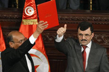 De president van Tunesië Moncef Marzouki (links) en voormalig eerste minister Ali Larayedh poseren na het ondertekenen van de nieuwe grondwet in Tunis.