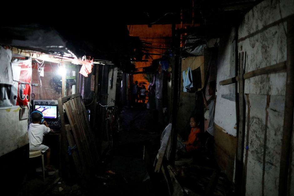 Een jongetje in een geïmproviseerd internetcafé in een sloppenwijk in Manila, Filipijnen.