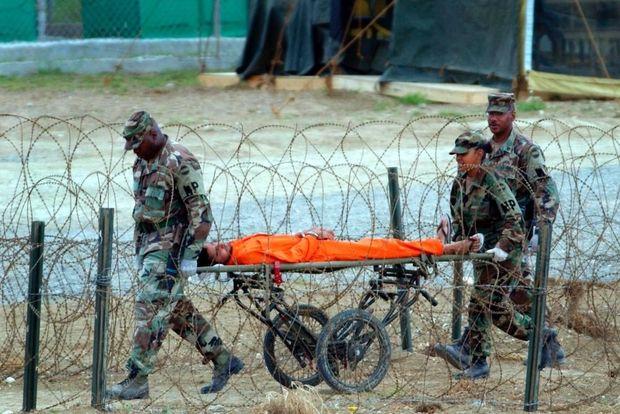Een gevangene van Guantanamo Bay wordt weggedragen na een ondervraging, 2002. 