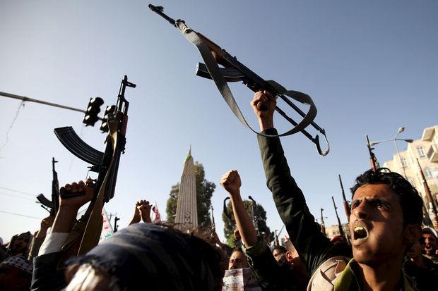 Houthi-aanhangers steken hun wapens de lucht in.